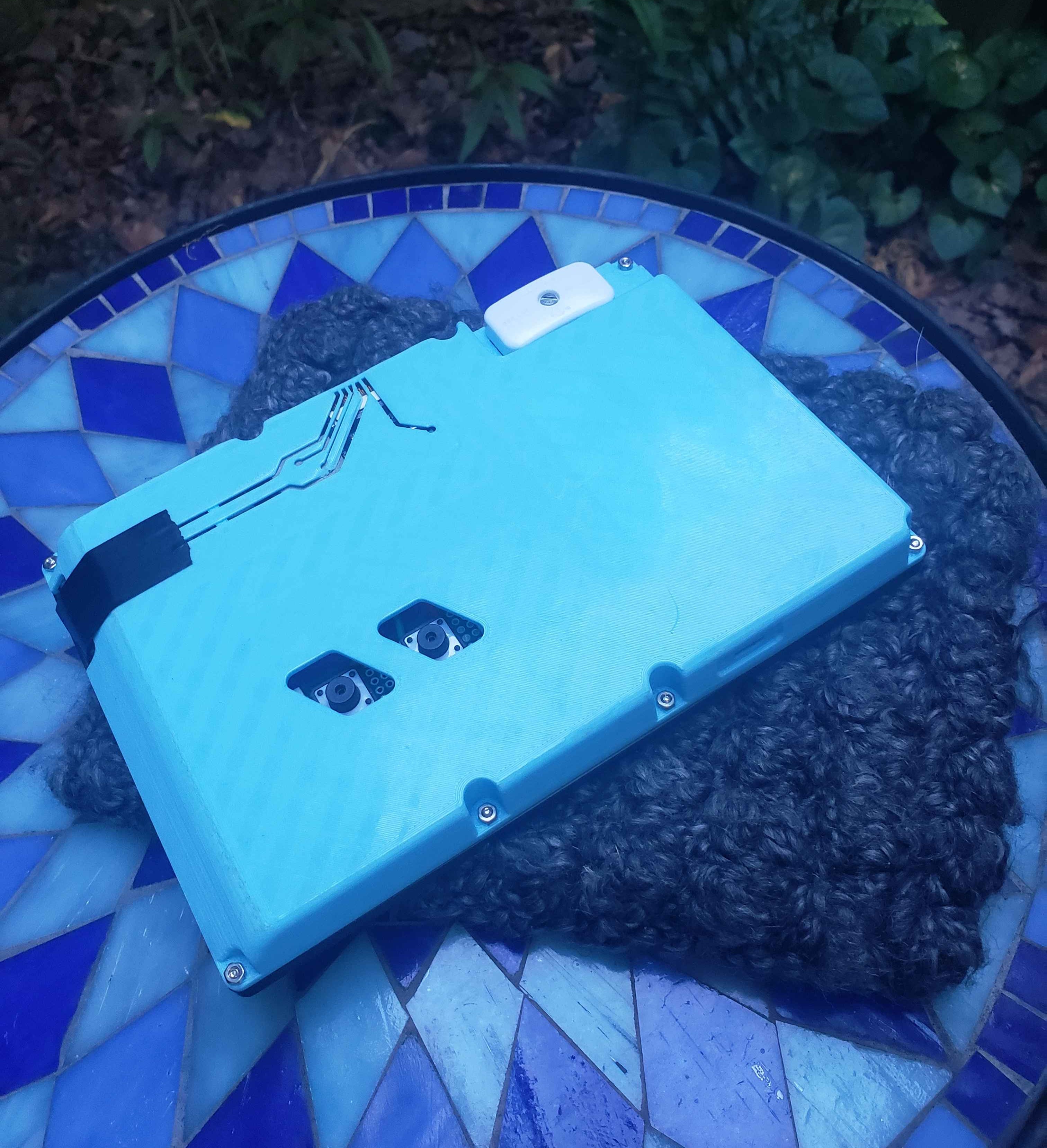 Back of the e-reader, printed in a blue PLA. A circuit trace design exposes some of the internals